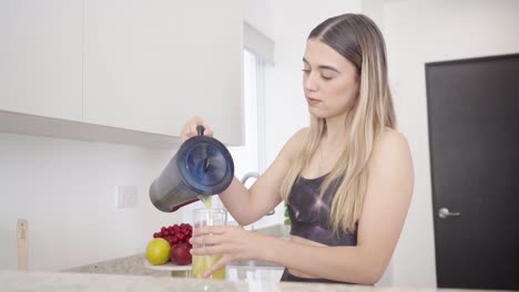 young healthy teenager making nutritious fruit smoothie after workout