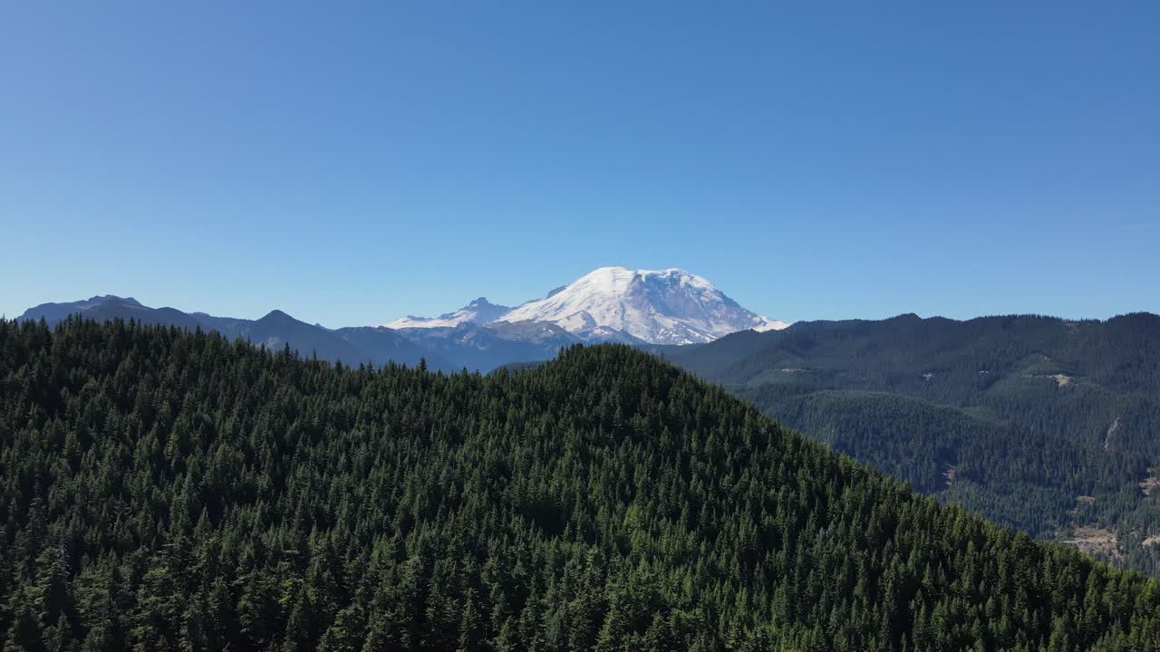Aerial footage going forward of Mount Rainier on a clear blue day