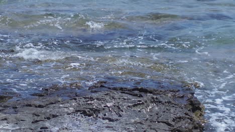 waves at sea crushing against the rocks on the shore. tidal wave hitting the cliffs on the coastline in summer.