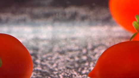 tomatoes fall into the water on a white background. slow motion 250fps