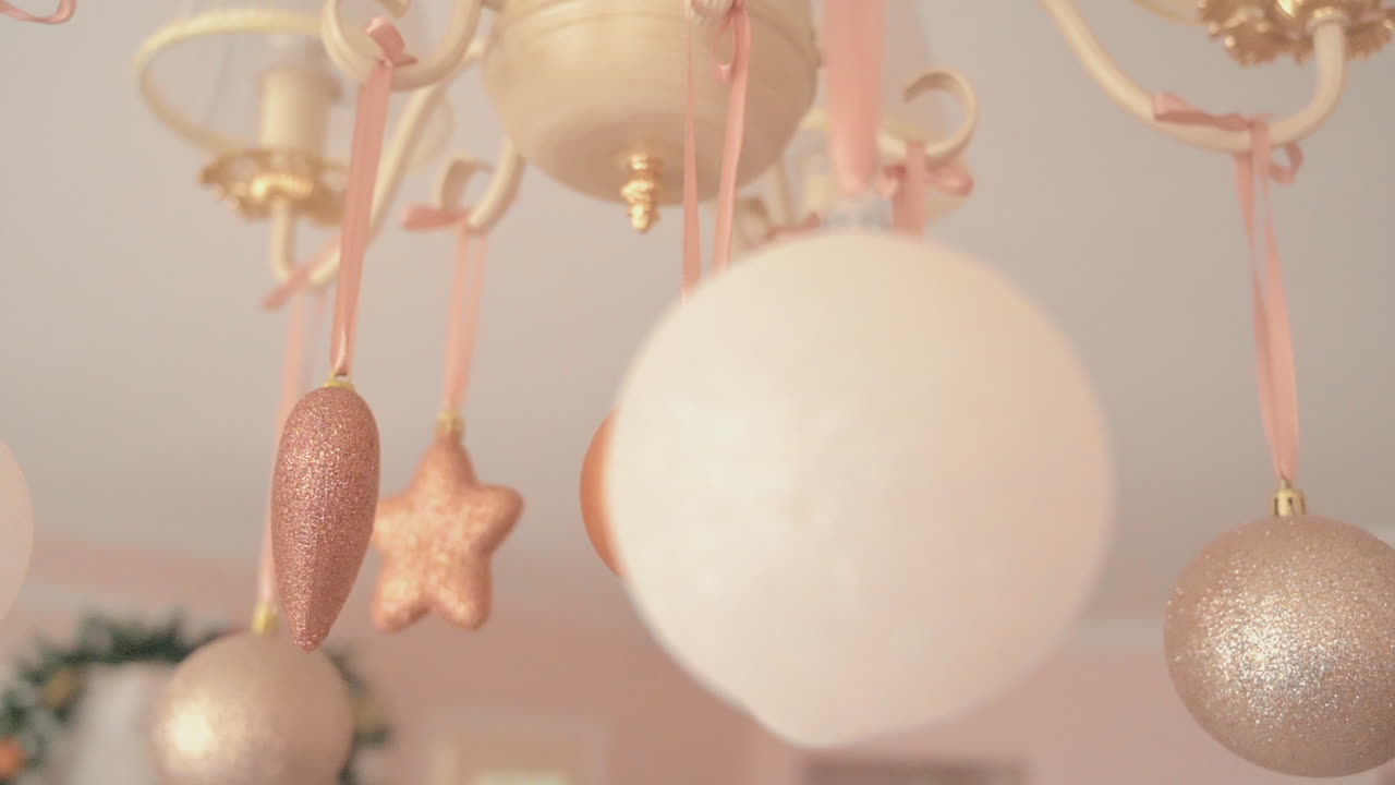ピンクと白の装飾が、ピンクの部屋にあるシャンデリアに飾られています。