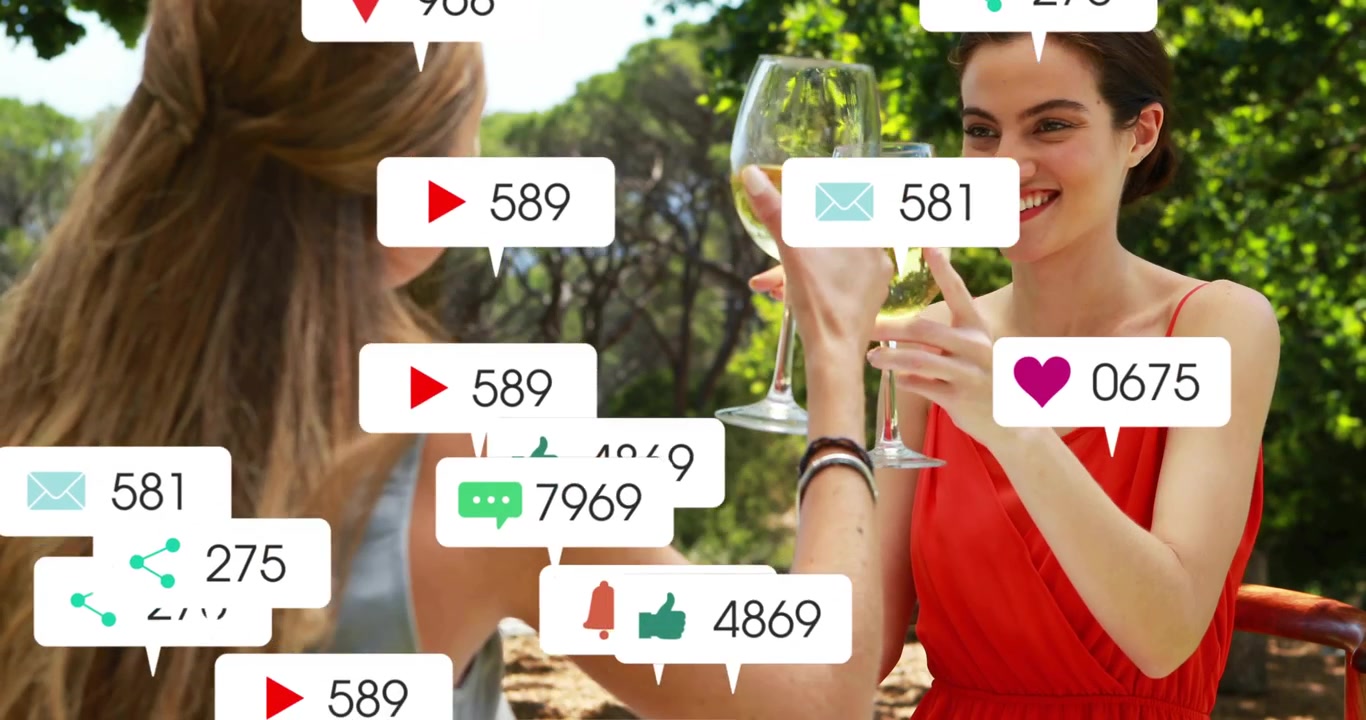 Dos mujeres brindando con vino en un patio, con burbujas de alerta de redes sociales cubriendo sus rostros.
