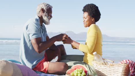 Feliz-Pareja-Afroamericana-Haciendo-Un-Picnic-En-La-Playa-Soleada