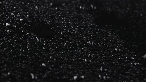 shooting of rainy drops on black glass background