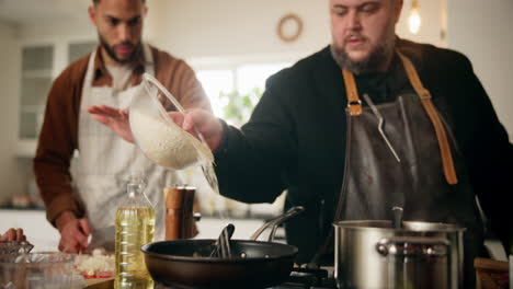 two men cooking rice in kitchen