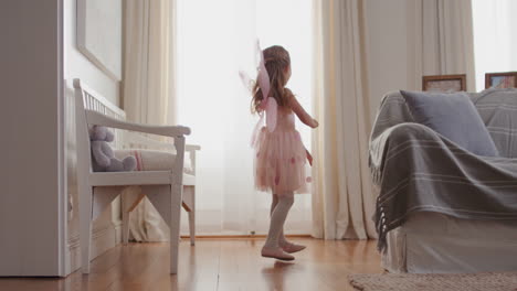 Linda-Niña-Bailando-Juguetonamente-Haciéndose-Pasar-Por-Bailarina-Niña-Feliz-Divirtiéndose-Jugando-A-Disfrazarse-Usando-Traje-De-Ballet-Con-Alas-De-Hada-En-Casa-4k