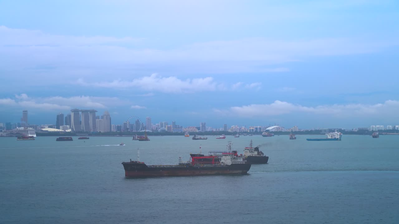 夕暮れ時、シンガポールの街並みを背景に、物流船やボートが港を埋め尽くす