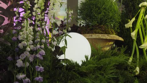 Slow-orbiting-shot-of-a-light-ball-within-a-botanical-scene-at-a-fashion-show