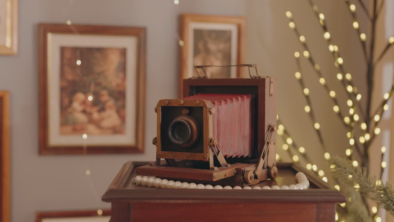 Old bellows camera displayed indoors with festive warm holiday lighting