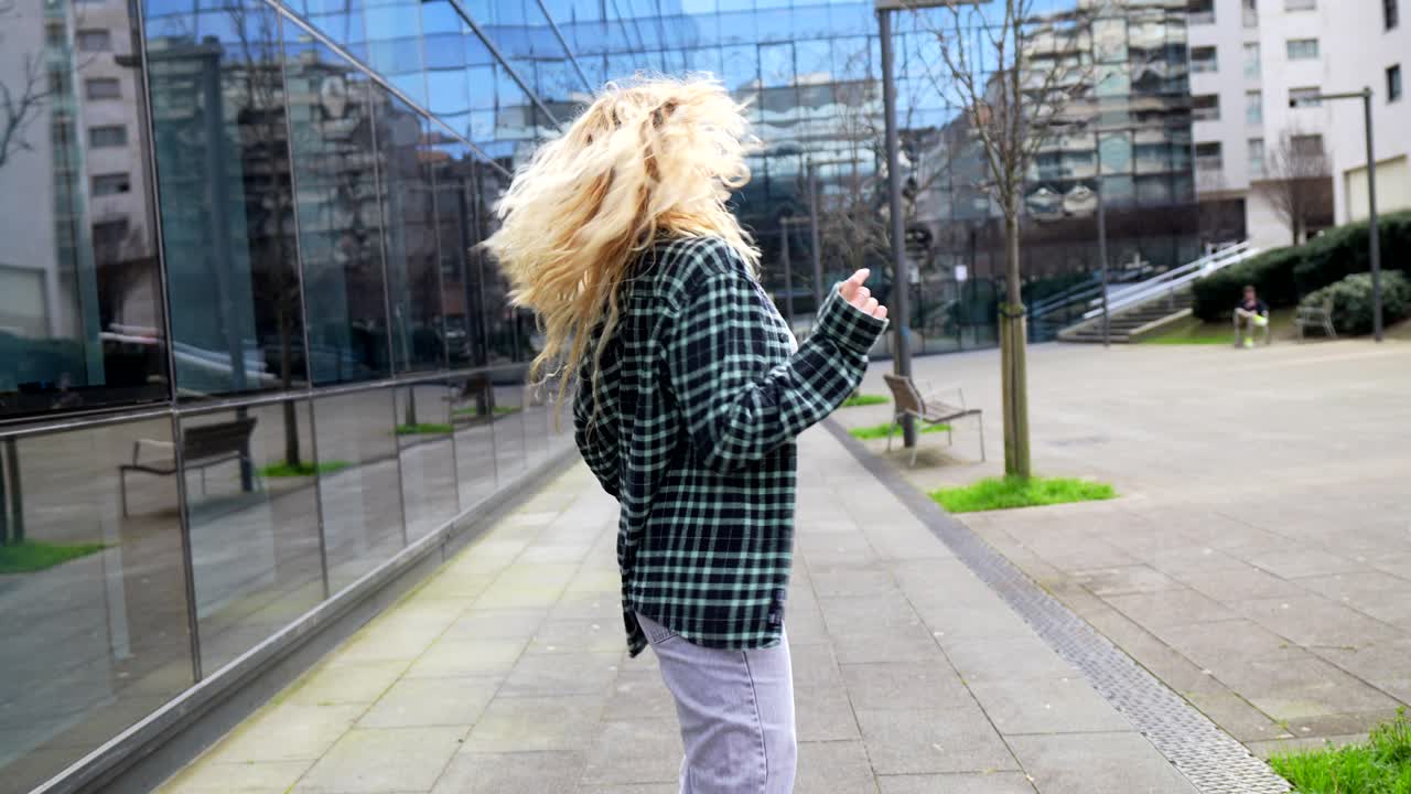 Woman in flannel shirt dancing in the city