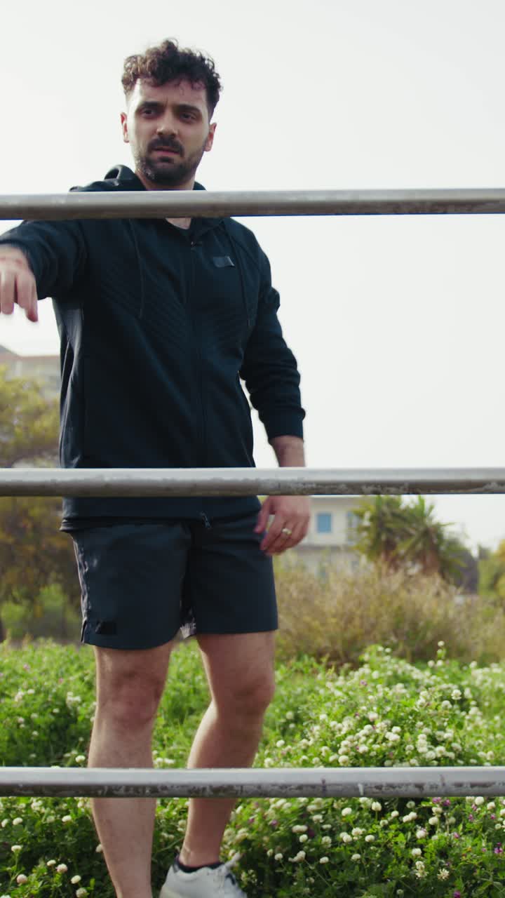Man Trains Upper Body on the Bars in the Park