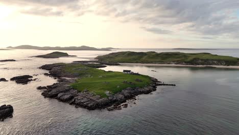 tiny cottage on an island off the coastline of ireland just before sunset
