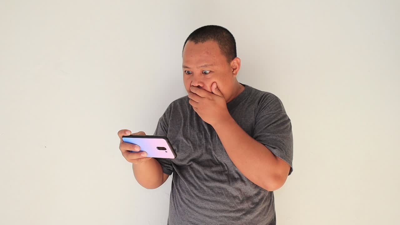 감정이 가득한 남자는 스트레스 받은 표정으로 스마트폰에 메시지를 입력하고 있다