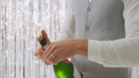 young man opening champagne