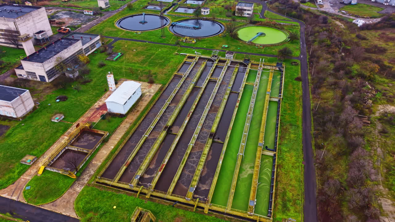 View of a water treatment facility with multiple tanks and filtration systems in operation during daytime in an industrial area