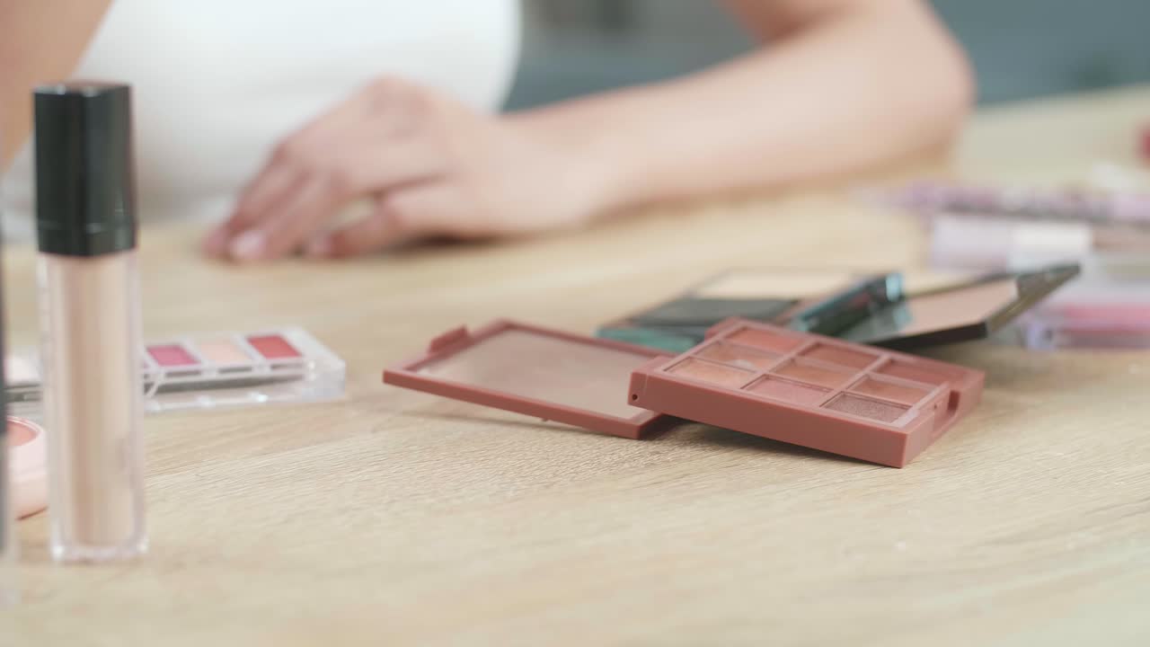 manos femeninas sosteniendo el rizador de pestañas en la vanidad y usándolo para aplicar maquillaje en casa