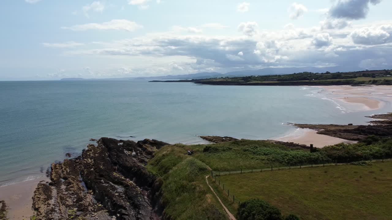 lethligwy idílica costa rocosa línea de costa vista aérea en órbita a través de pastos verdes en el borde de acantilados rocosos