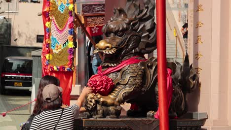 people interacting with dragon statue at temple