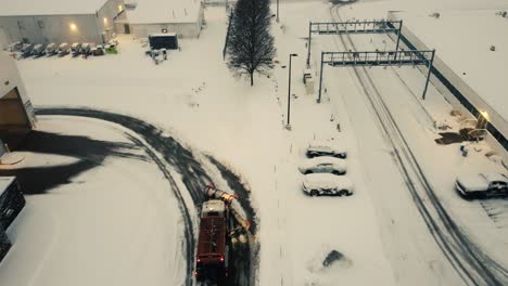 drone shot truck with snowplough driving in heavy winter storm in usa