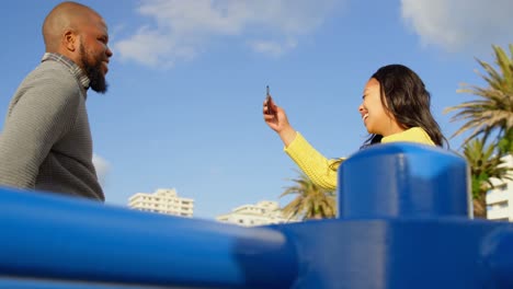 pareja tomando una foto con el teléfono móvil en el parque en un día soleado 4k