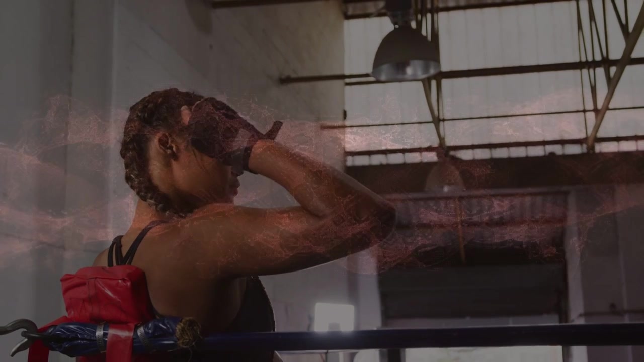 Boxer resting in boxing corner raising glove adjusting wraps preparing next while pink smoke rising