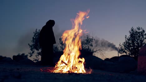 wicked witch holds ritual by the fire. halloween costume.