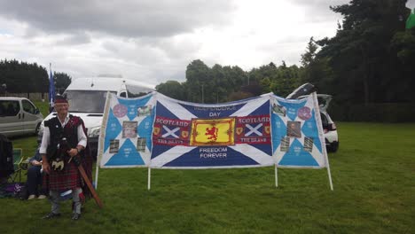 a pro-independence supporter next to a homemade banner.