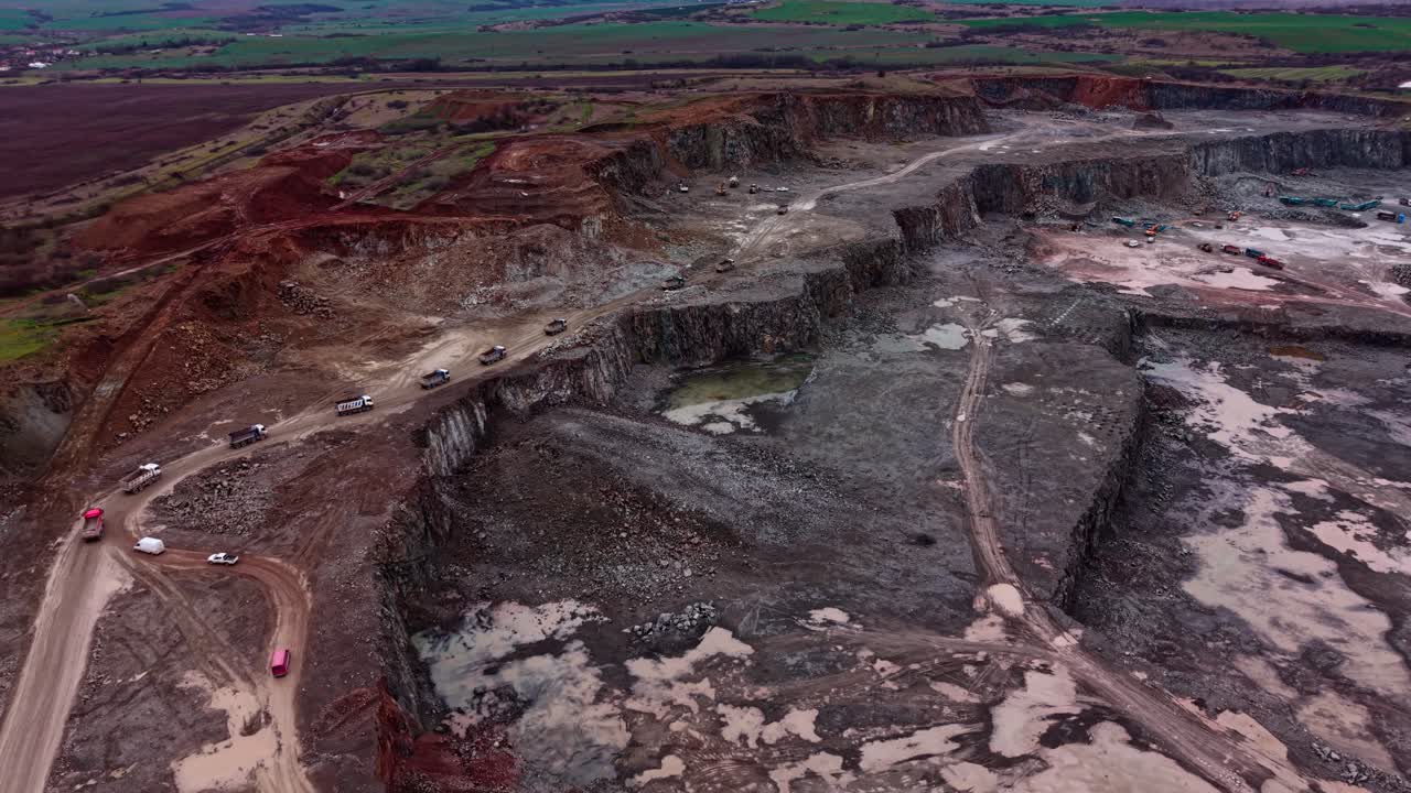 Granite quarry in an industrial area with vehicles on a dirt road