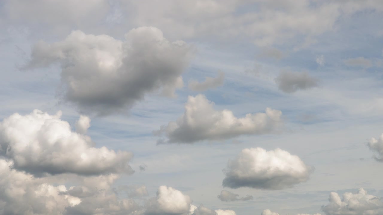 Fluffy clouds moving against blue skies