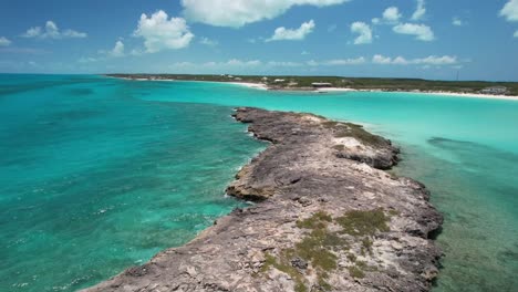 aerial view of rocky coast with turquoise sea during summer in bahamas - drone shot