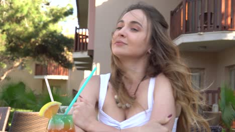 beautiful girl drinks a rainbow cocktail