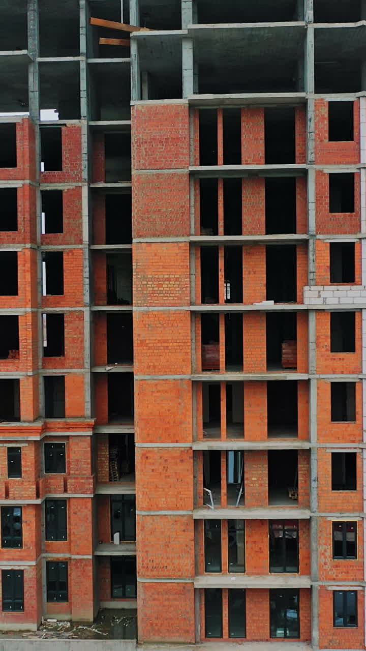 Construction of a residential apartment complex. View from the bottom to the top. Vertical video