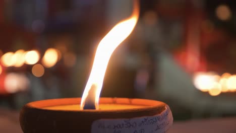 vista detallada de las velas encendidas frente al templo budista en la noche durante el festival loy krathong en chiang mai, tailandia