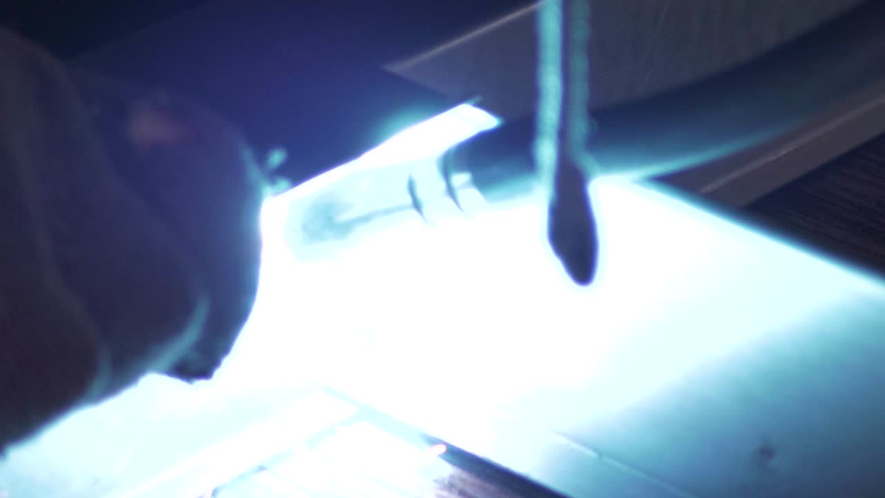 Welder works in metal construction - construction and processing of steel components, slow motion