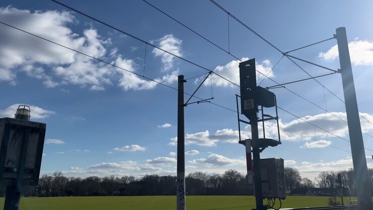 black traffic light for tram in nice weather with railway track in the background