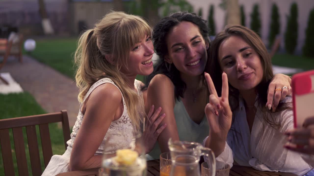 베란다 카페 야외에서 스마트폰으로 셀카 사진이나 비디오를 찍는 평온한 여성