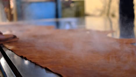 steaming leather on the table of the tannery processing plant in ethiopia. - closeup shot