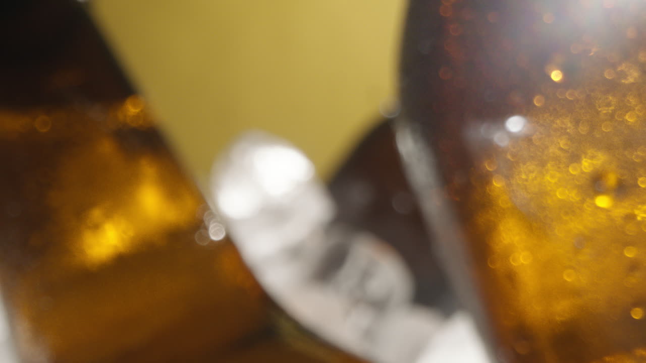 Close Up Of Condensation Droplets Running Down Glass Bottles Of Cold Beer Or Soft Drink Chilling In Ice Filled Bucket Against Yellow Background 2