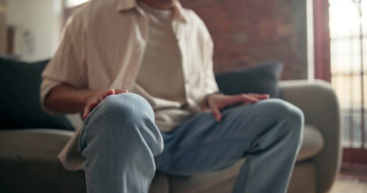 Uomo seduto sul divano in abbigliamento casual