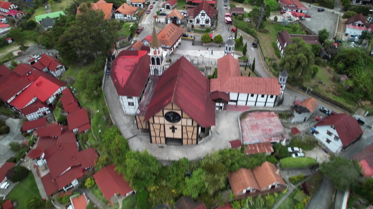 Colonia Tovar -vuoristokylä, punakattoiset talot rehevällä maaseudulla, Venezuela, ilmakuva (dolly out)
