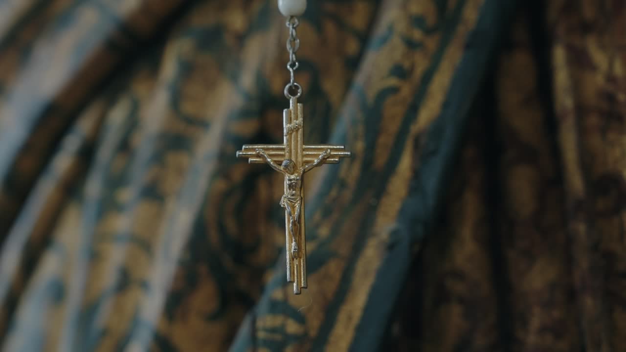 Close view of a gold crucifix pendant gently hanging in soft light