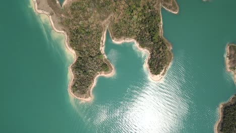 Aerial View of Turquoise Lake with Forested Islands and Boat