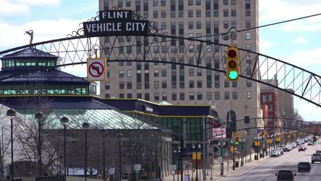 establishing shot of flint michigan main street and arch saying vehicle city