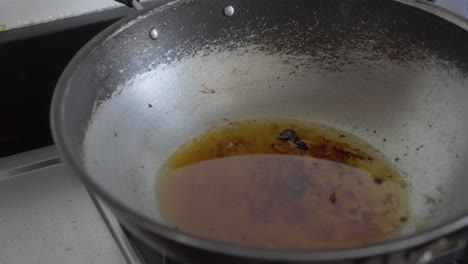 wok with used cooking oil on stove in kitchen, gimbal orbit