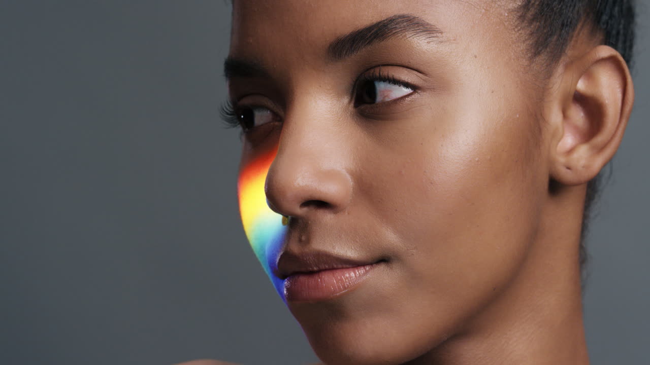 retrato multicolor de cerca hermosa mujer afroamericana con luz colorida que se refleja en la cara piel perfecta con aspecto saludable concepto de cuidado de la piel