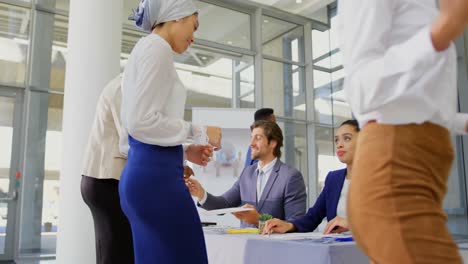 Business-people-checking-in-at-the-conference-registration-table-4k