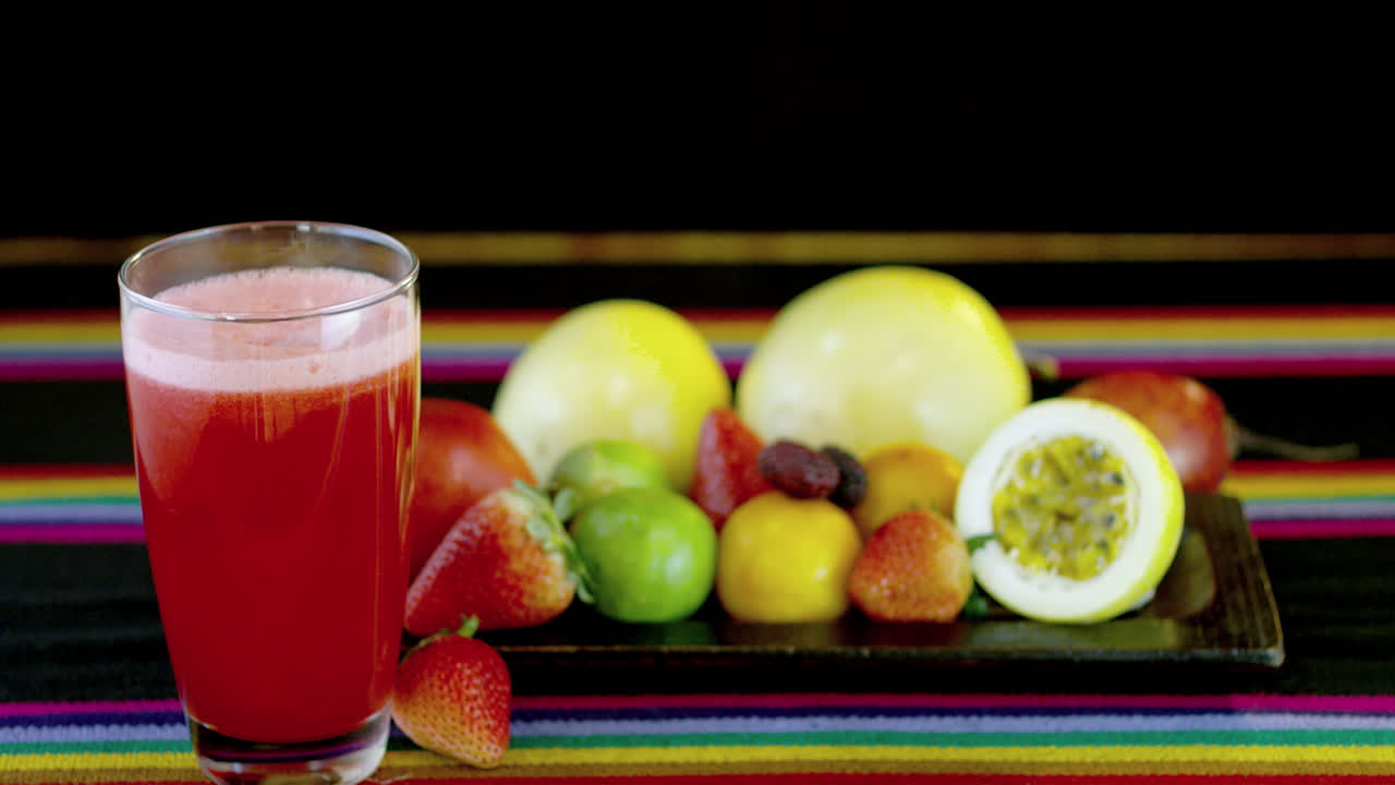 frutas frescas y un vaso de jugo de fresa