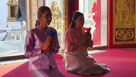 women praying in a thai temple