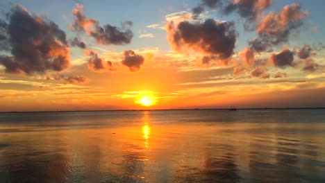 fondo de puesta de sol tropical con nubes de colores que se reflejan en el agua