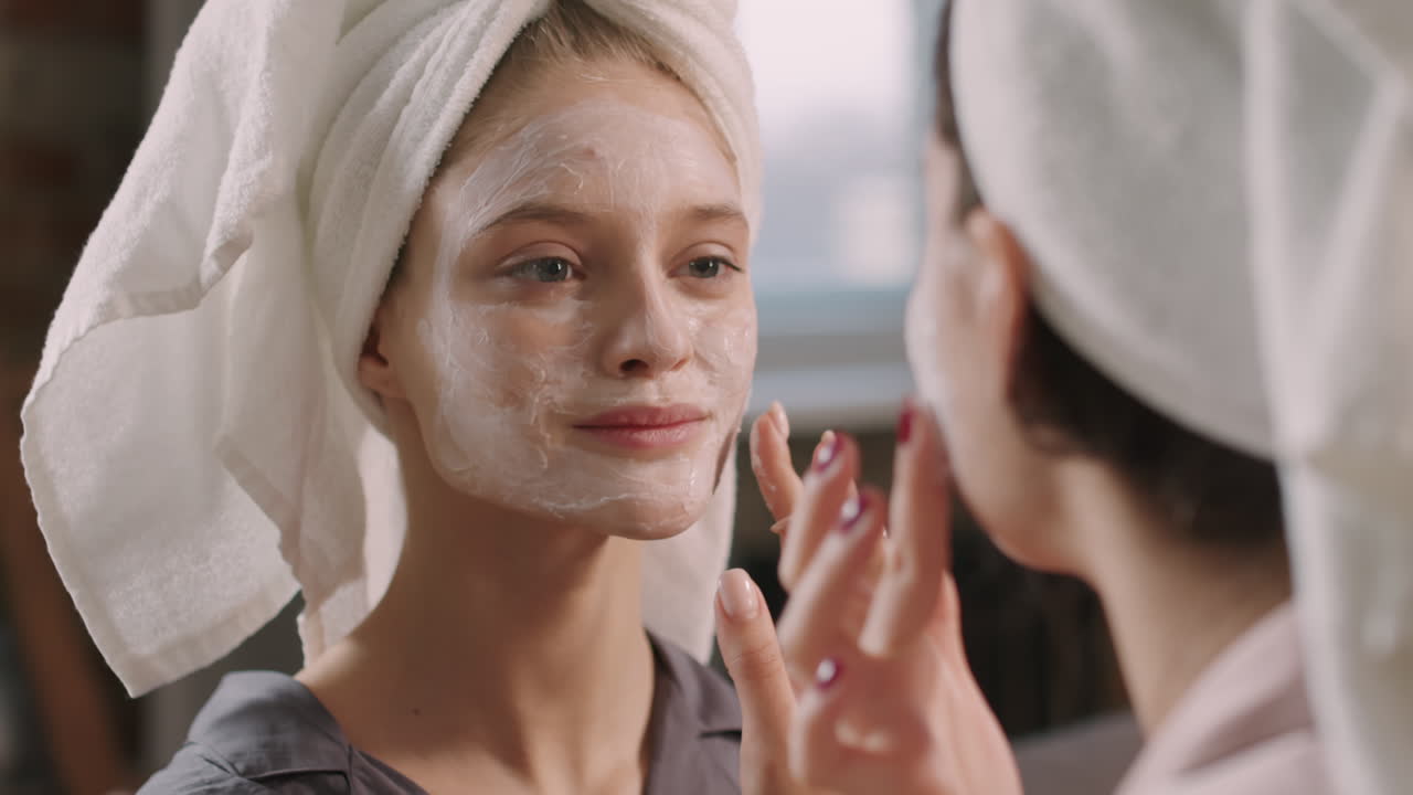 Female Friends Applying Facial Clay Mask